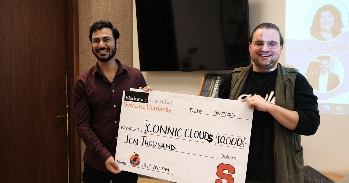 two people holding large check