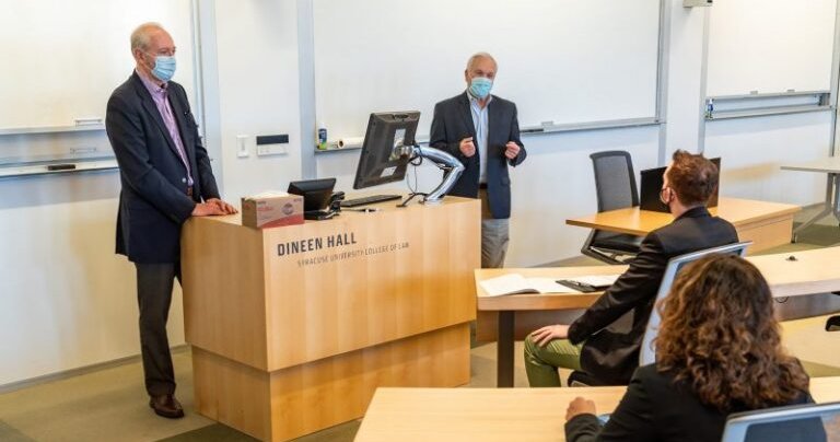 a group of people having conversation in a room located in Dineen Hall