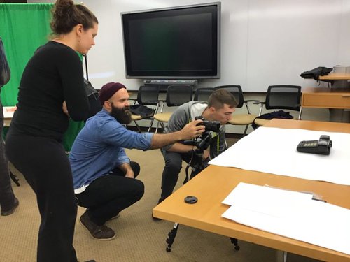 Teacher adjusting position of camera for student