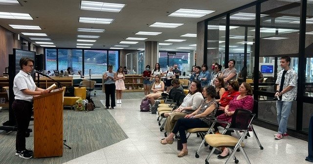 person reading from banned book at podium