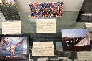 book covers depicting landscape scenes with brief description next to them in display case