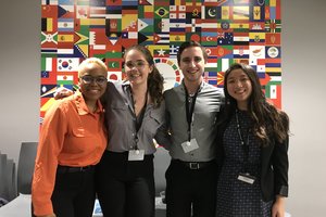 Innovators pose for a picture in front of country flags from around the world