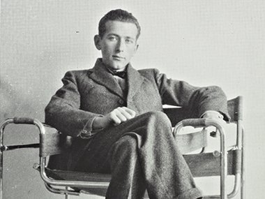 black and white of man sitting in chair