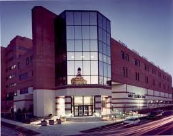 corner building with glass on upper level front, brick on bottom and sides