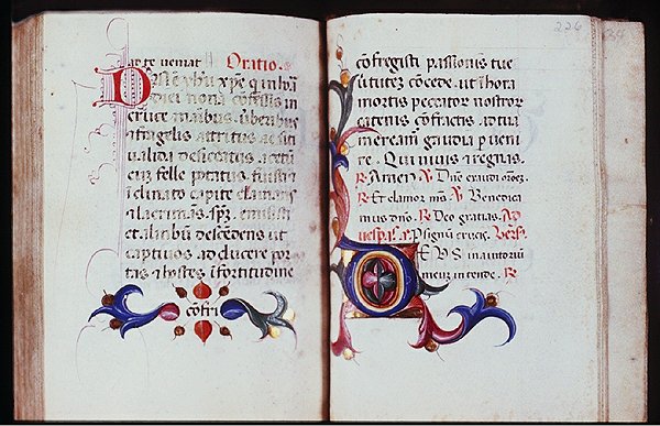 medieval book spread open with 2 pages that include antique font type and colorful ornate illustrations around bottom