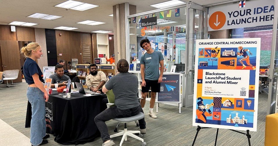 students standing and sitting near table in front of LaunchPad