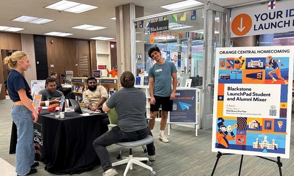 students standing and sitting near table in front of LaunchPad
