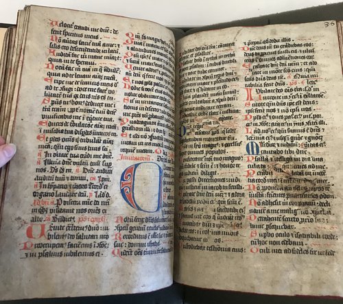 Two pages of a medieval manuscript with red, blue, and black text