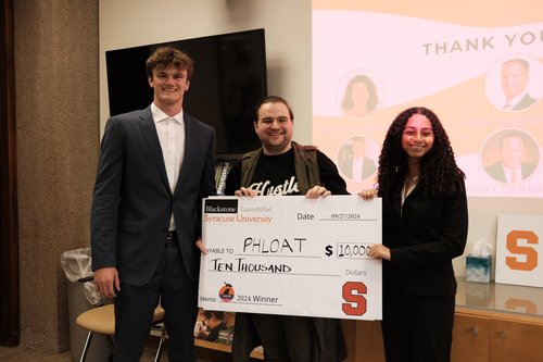 three people holding large check