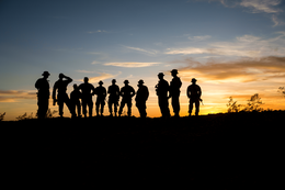 silhouette of people in military at sunset