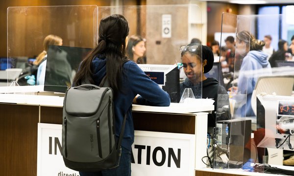 people at the information desk in Bird Library