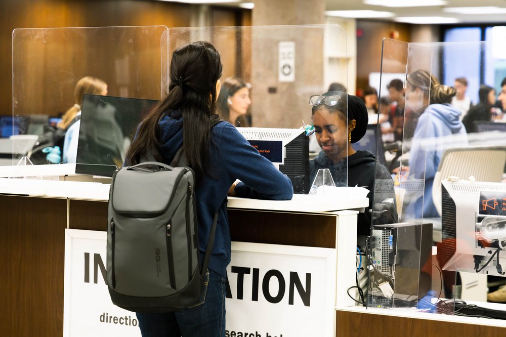 people at the information desk in Bird Library