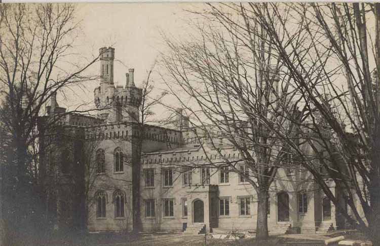 tan gothic building with trees around it