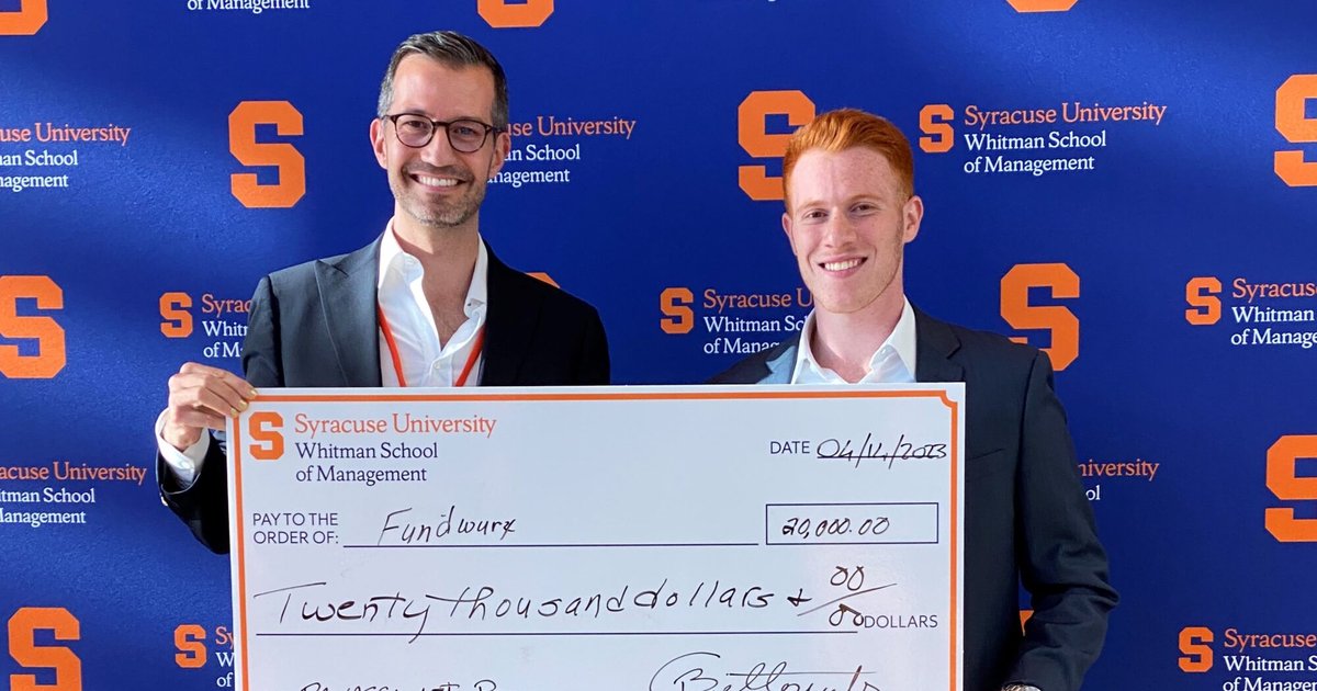Cristiano Bellavitis hands an oversized check to Ben Ford