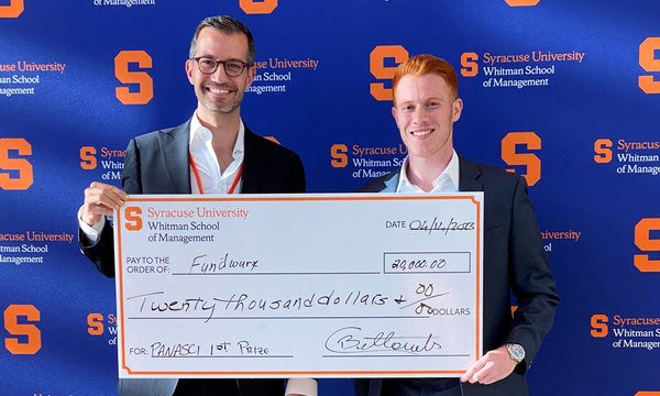 Cristiano Bellavitis hands an oversized check to Ben Ford