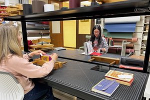 two people working in library repairing books