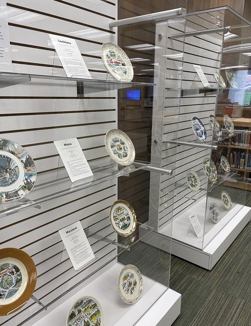 two display cases featuring plates and descriptions next to each one