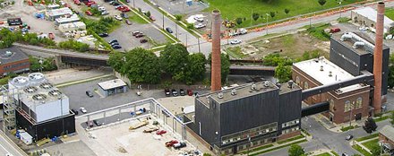 aerial view of several buildings with long brick chimneys high above building height