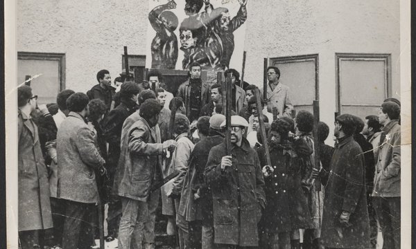 group of Black students standing in together with a couple in center lifted up