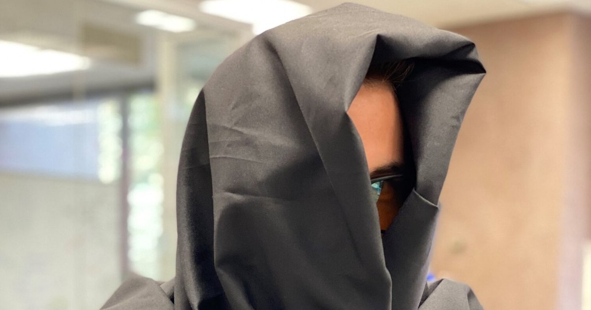 student covered in gray fabric