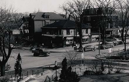 aerial view of busy corner with buildings and cars crossing intersection