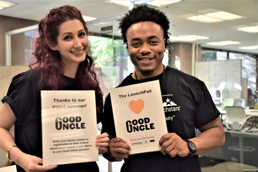 two people holding good uncle signs