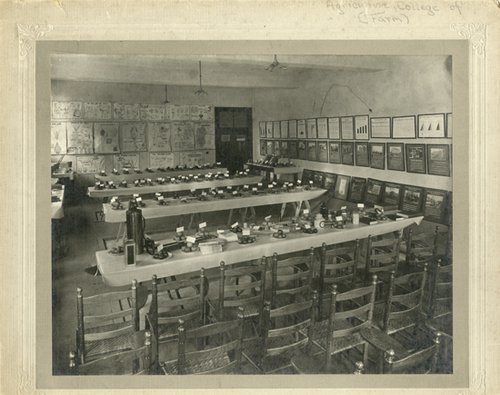 several tables in row with items on the tables, chairs in rows at bottom of photo