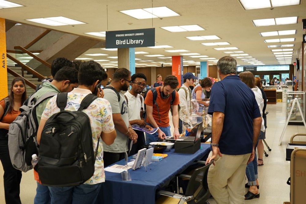 students standing around table with items from special collections on table